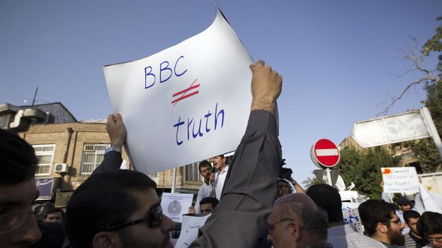 Un étudiant iranien brandit une affiche contre la BBC Un étudiant iranien brandit une affiche contre la BBC