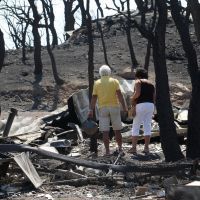 Des touristes contemplent le camping dévasté